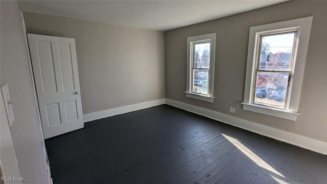 unfurnished room with plenty of natural light and dark hardwood / wood-style flooring