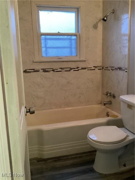 bathroom with toilet, tiled shower / bath combo, and hardwood / wood-style flooring