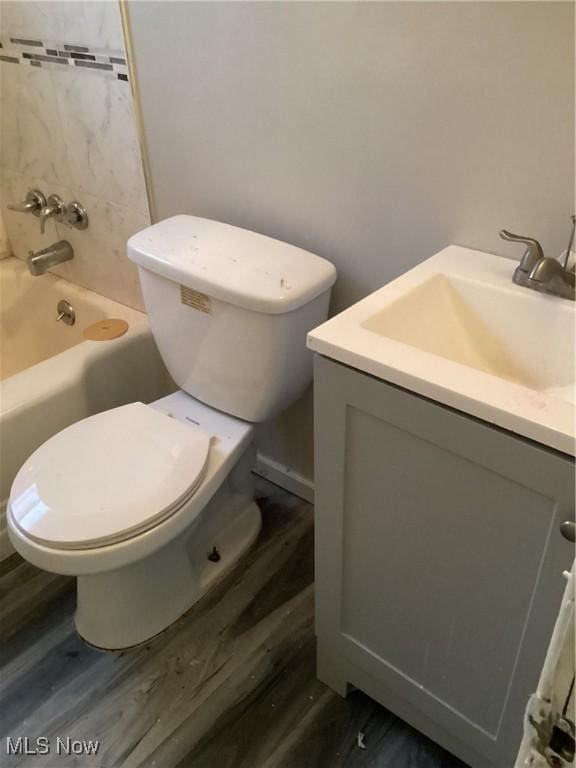 full bathroom featuring hardwood / wood-style flooring, vanity, shower / bathtub combination, and toilet