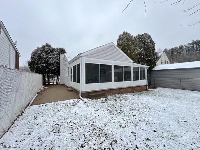 snow covered house with a sunroom