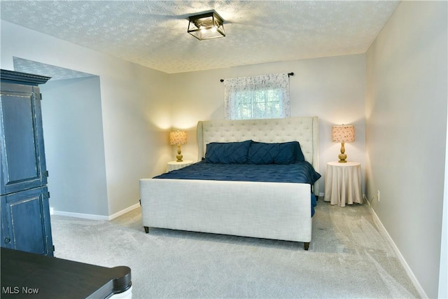 bedroom featuring light carpet and a textured ceiling