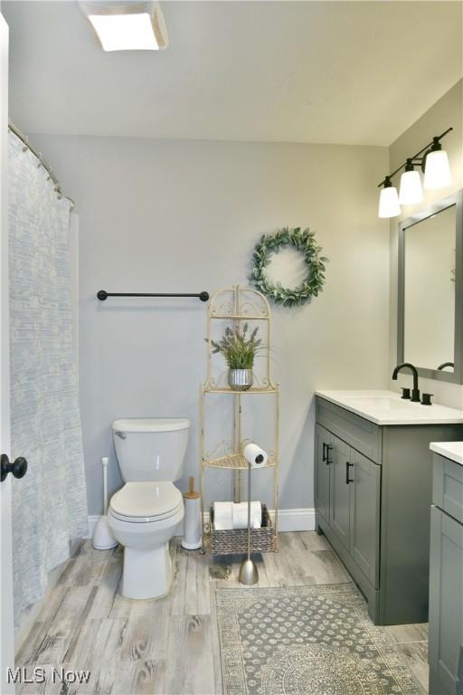 bathroom with hardwood / wood-style floors, vanity, and toilet