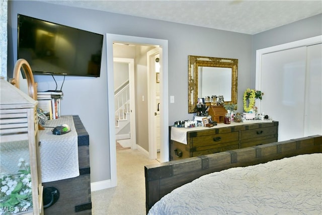 bedroom featuring a textured ceiling and light carpet