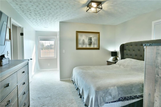 bedroom with light carpet and a textured ceiling