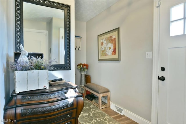 foyer entrance featuring wood-type flooring and a textured ceiling