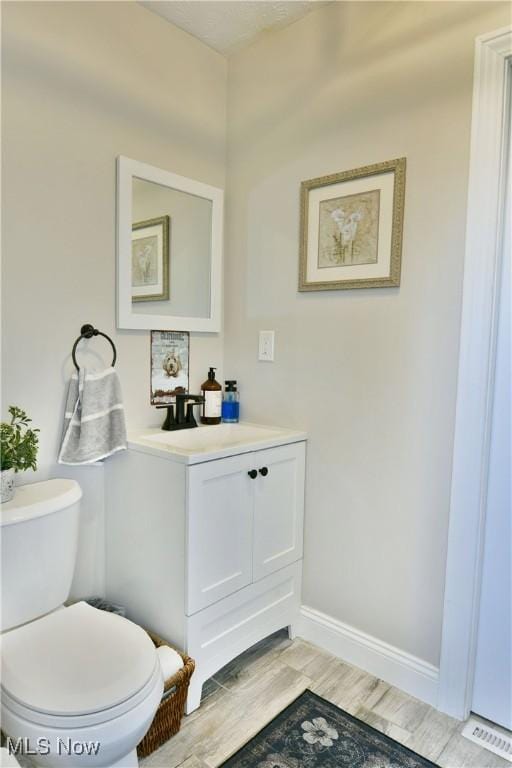 bathroom featuring vanity, toilet, and wood-type flooring