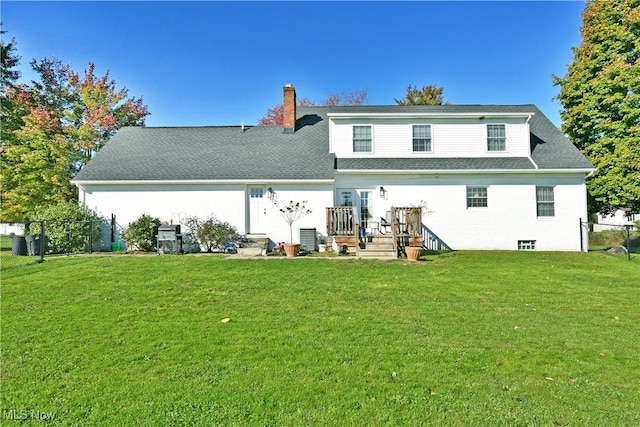 rear view of house featuring a lawn