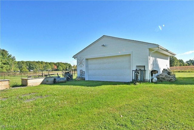 exterior space featuring a lawn, a garage, and an outdoor structure