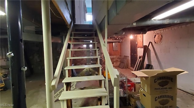 stairs featuring concrete flooring