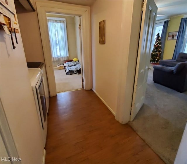 hallway with light wood-style flooring and washer and dryer
