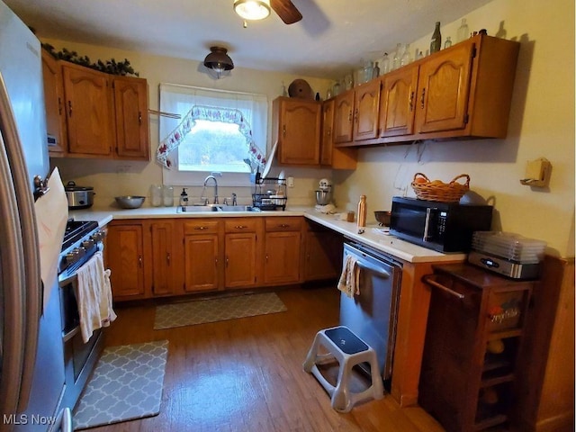 kitchen with fridge, sink, stainless steel range with gas stovetop, ceiling fan, and dark hardwood / wood-style floors