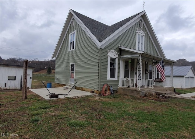 exterior space featuring covered porch, a front yard, and a patio