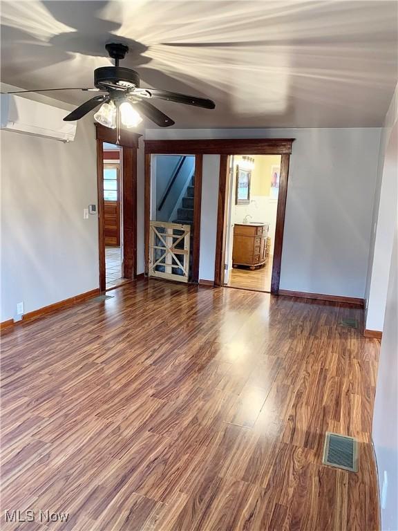 unfurnished living room with wood-type flooring and ceiling fan