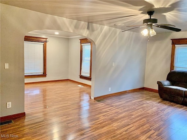 unfurnished living room featuring hardwood / wood-style flooring, ceiling fan, and ornamental molding