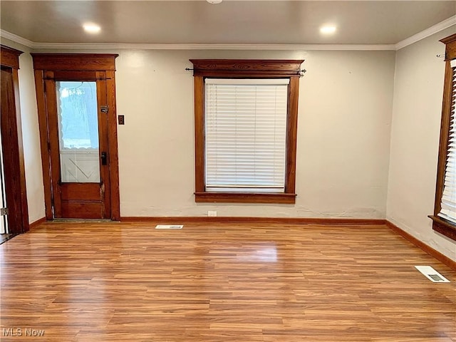 empty room featuring light hardwood / wood-style flooring and ornamental molding