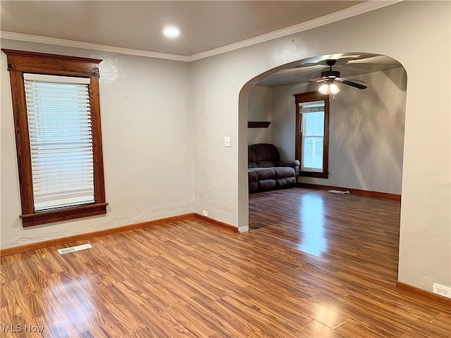 empty room with hardwood / wood-style flooring, ceiling fan, and ornamental molding