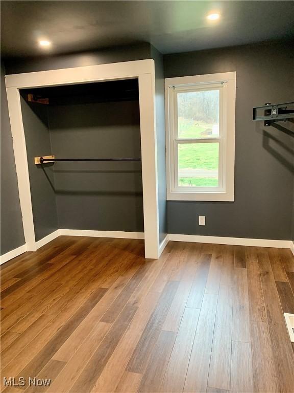 unfurnished bedroom featuring wood-type flooring and a closet