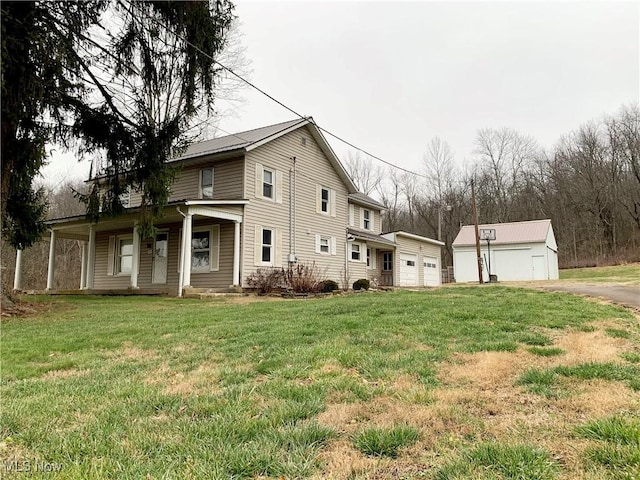 view of property exterior featuring a lawn, a garage, covered porch, and an outdoor structure