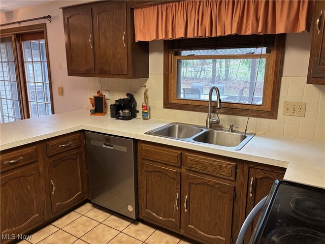 kitchen featuring decorative backsplash, dishwasher, stove, and sink