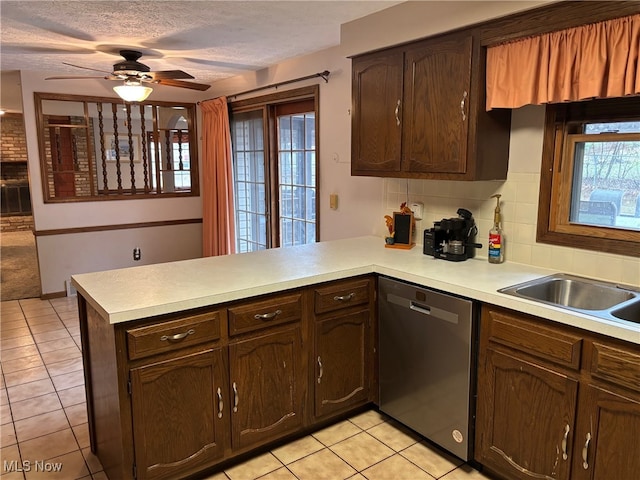 kitchen with stainless steel dishwasher, ceiling fan, light tile patterned floors, tasteful backsplash, and kitchen peninsula