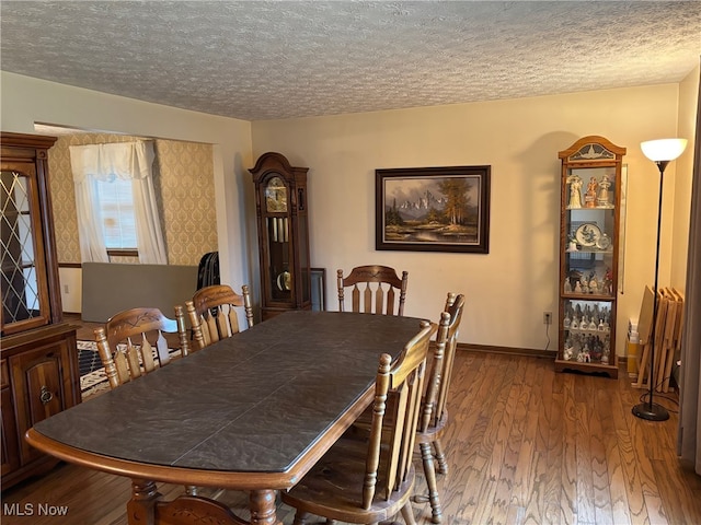 dining space with a textured ceiling and hardwood / wood-style flooring