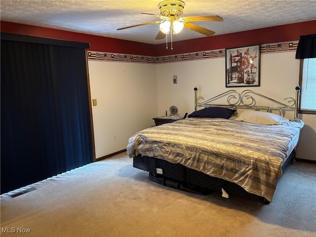 bedroom with carpet flooring, a textured ceiling, and ceiling fan