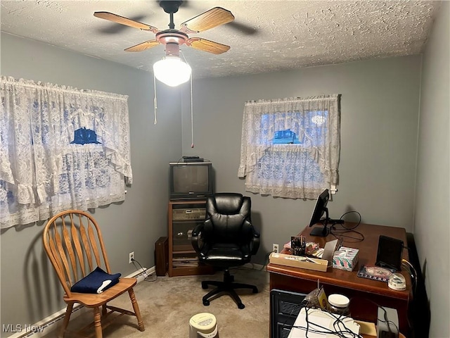 carpeted office space featuring ceiling fan and a textured ceiling