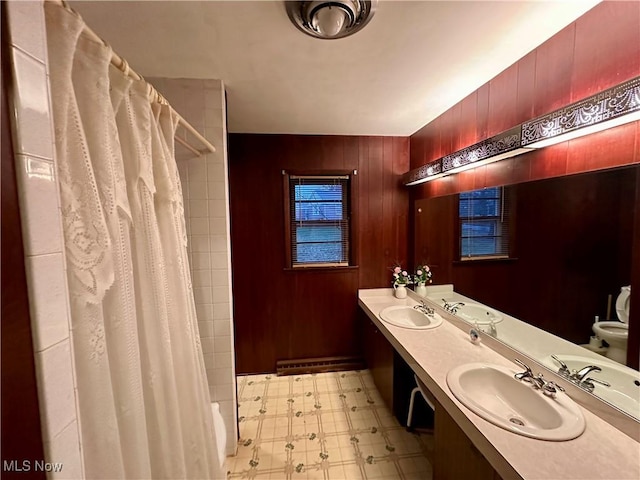 bathroom featuring a shower with curtain, vanity, and wooden walls