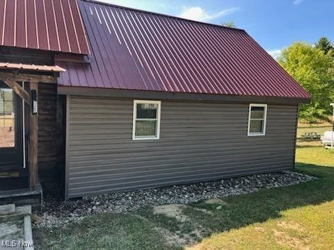 71352 Skyline Dr, Piedmont, OH 43983 - view of home's exterior featuring a lawn, metal roof, and a garage