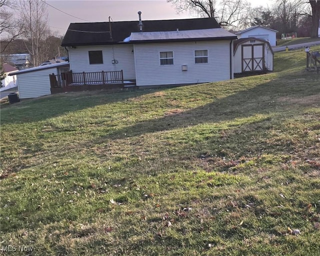 yard at dusk featuring a deck and a storage shed