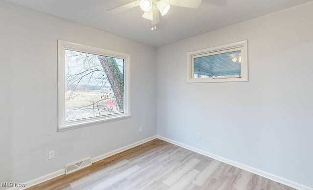 spare room with ceiling fan and light wood-type flooring