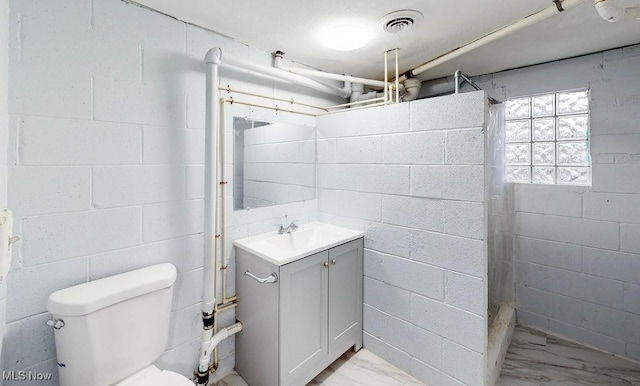 bathroom featuring vanity, toilet, and walk in shower