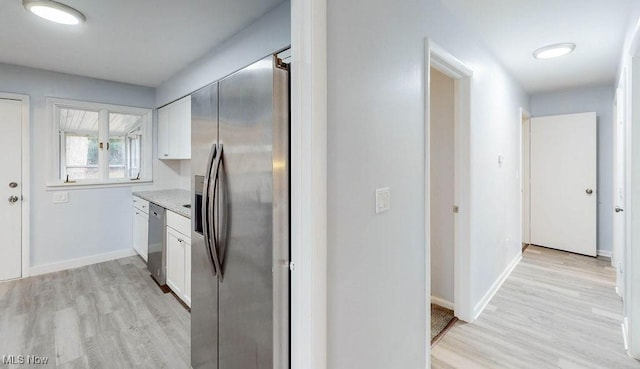 kitchen featuring stainless steel appliances, white cabinetry, and light hardwood / wood-style flooring