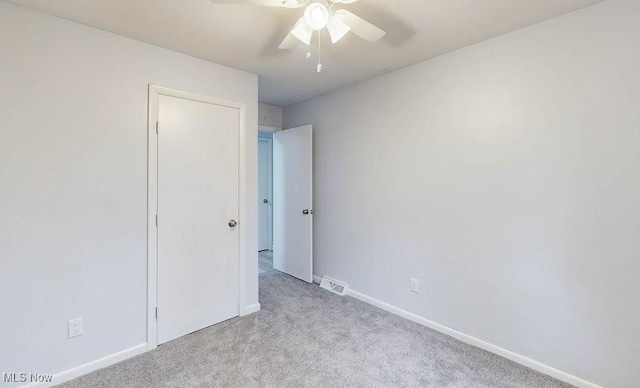 unfurnished bedroom with ceiling fan and light colored carpet