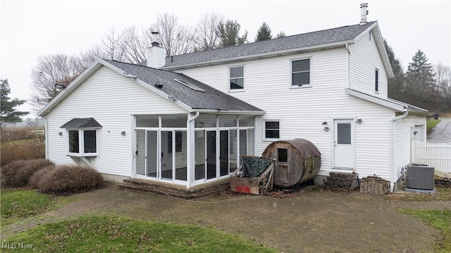 rear view of property with a sunroom and central AC unit