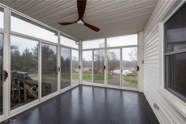 unfurnished sunroom with ceiling fan and a water view