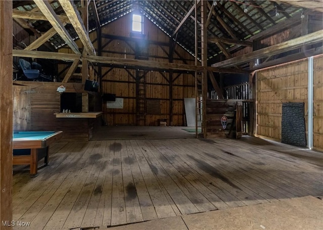 interior space with wooden walls, hardwood / wood-style flooring, lofted ceiling, and pool table