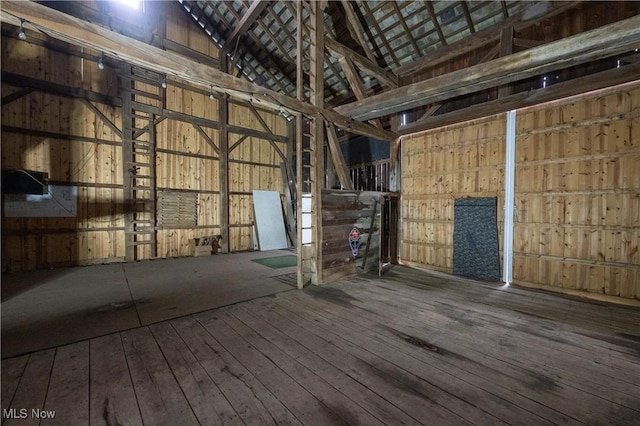 misc room featuring hardwood / wood-style floors, wooden walls, and lofted ceiling