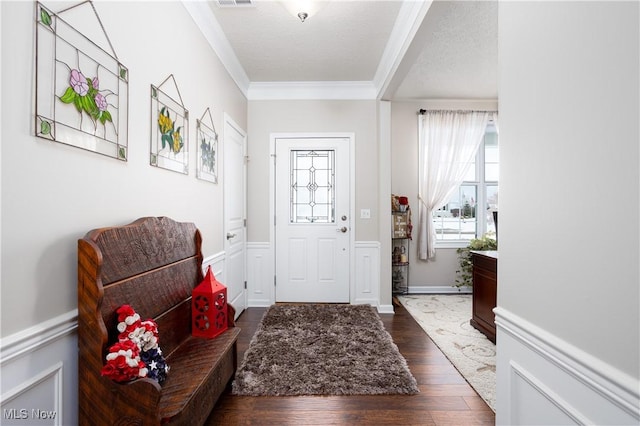 entrance foyer featuring a textured ceiling, dark hardwood / wood-style floors, and ornamental molding