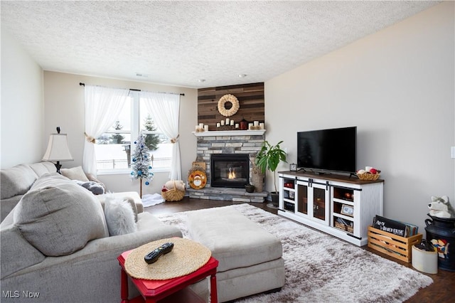 living room featuring hardwood / wood-style floors, a fireplace, and a textured ceiling