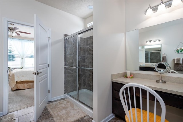 bathroom with vanity, a shower with door, tile patterned flooring, ceiling fan, and a textured ceiling