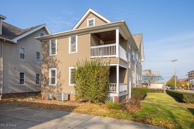 view of side of home featuring a balcony and central AC unit