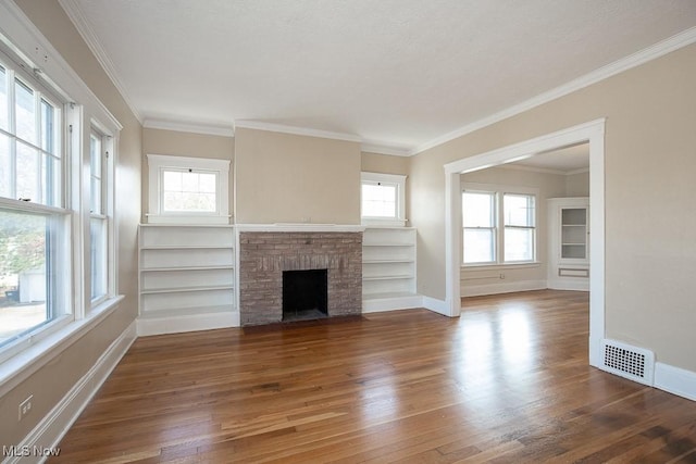 unfurnished living room featuring dark hardwood / wood-style floors, a healthy amount of sunlight, and a brick fireplace