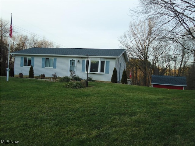 ranch-style home featuring a storage shed and a front yard