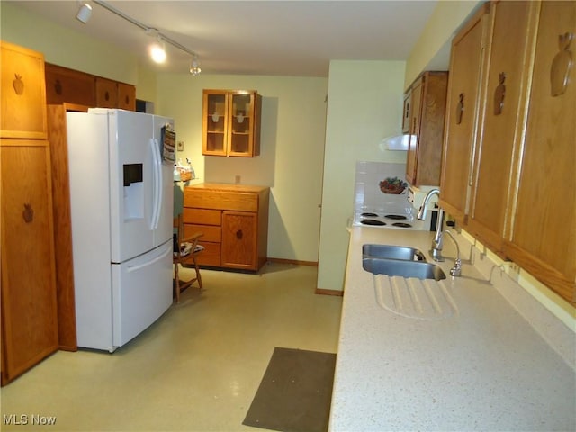 kitchen featuring rail lighting, white fridge, and sink