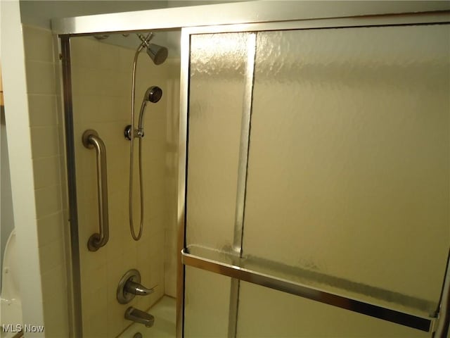 details with shower / bath combination with glass door