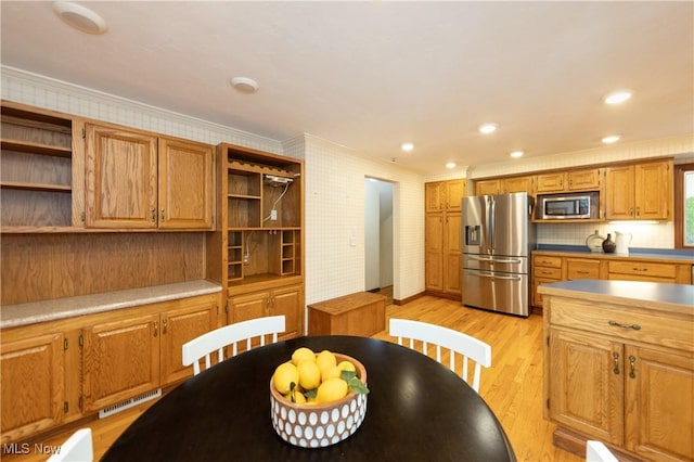 kitchen with decorative backsplash, stainless steel appliances, light hardwood / wood-style flooring, and crown molding