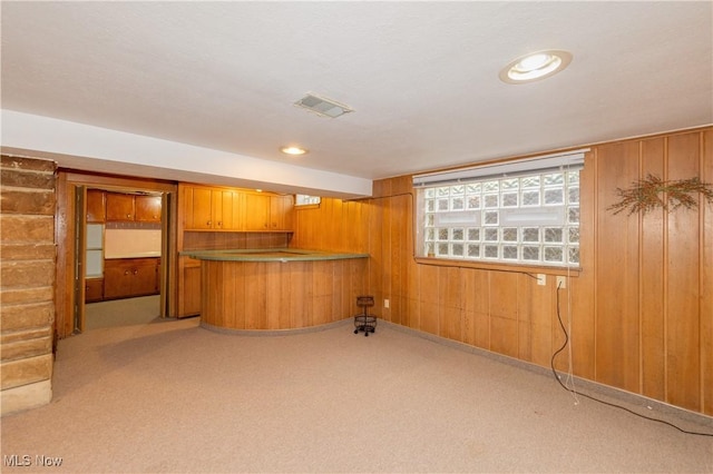 bar featuring wood walls and light colored carpet