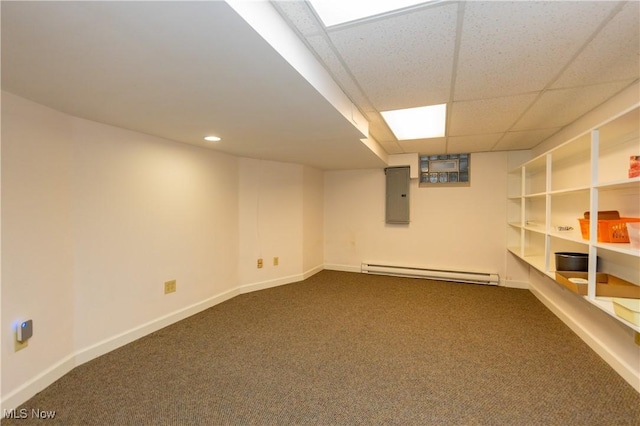 basement with carpet flooring, a paneled ceiling, baseboard heating, and electric panel