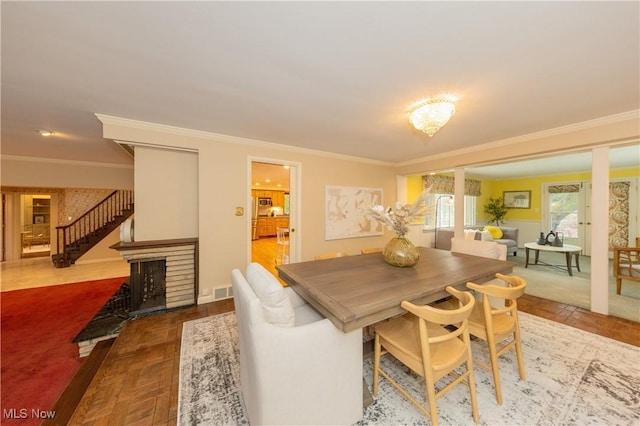 dining space featuring ornamental molding, parquet flooring, and a brick fireplace